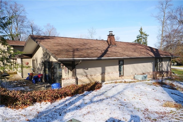 snow covered property featuring central AC unit