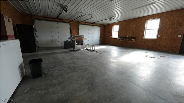 garage featuring white fridge and a garage door opener