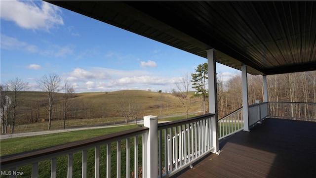 wooden terrace featuring a porch and a rural view