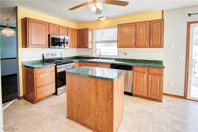 kitchen with ceiling fan, sink, decorative backsplash, a kitchen island, and appliances with stainless steel finishes