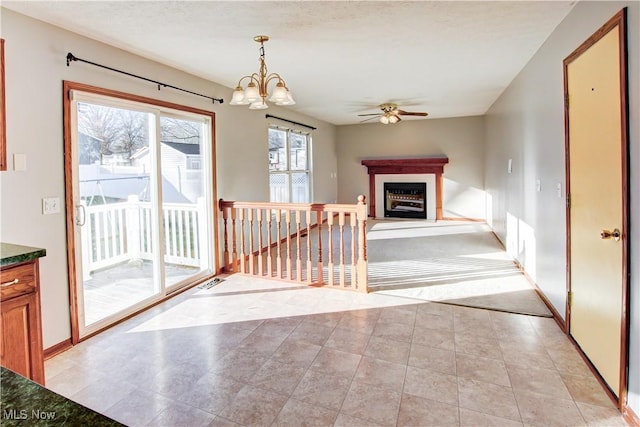 interior space with ceiling fan with notable chandelier