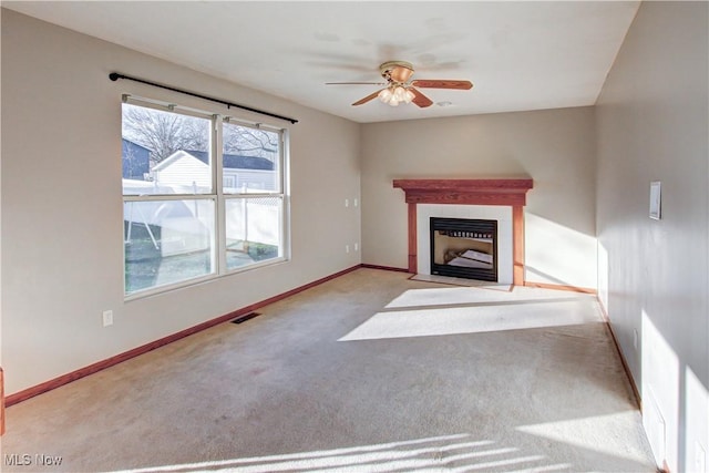 unfurnished living room featuring ceiling fan and light carpet