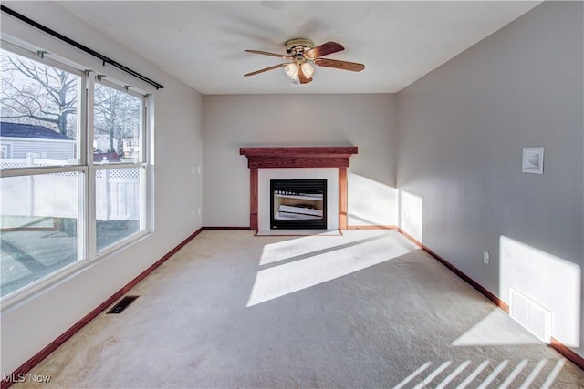 unfurnished living room with a fireplace, light carpet, and ceiling fan