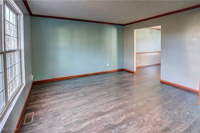 spare room featuring dark hardwood / wood-style flooring, ornamental molding, and a textured ceiling