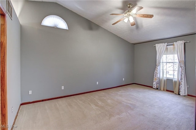 empty room with ceiling fan, light colored carpet, and lofted ceiling