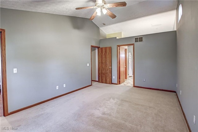 unfurnished room featuring a textured ceiling, ceiling fan, lofted ceiling, and light carpet