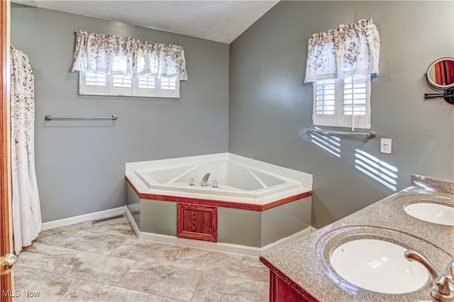 bathroom featuring a tub, vanity, and lofted ceiling