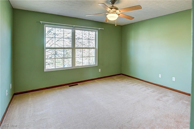 unfurnished room featuring a textured ceiling, ceiling fan, and light carpet