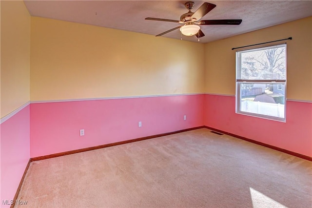 carpeted spare room featuring ceiling fan