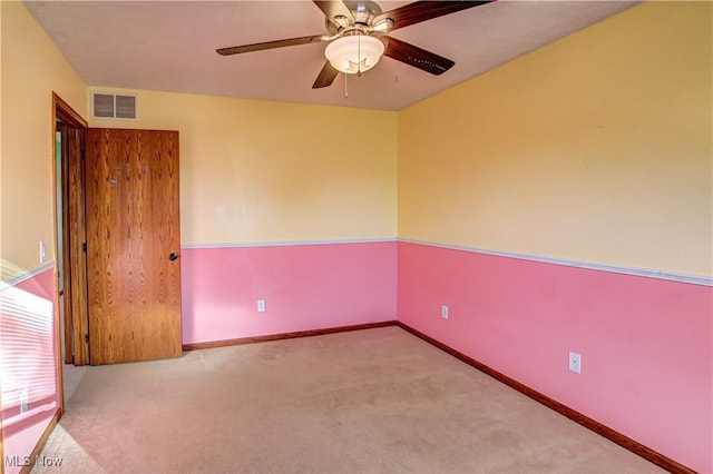 carpeted spare room featuring ceiling fan