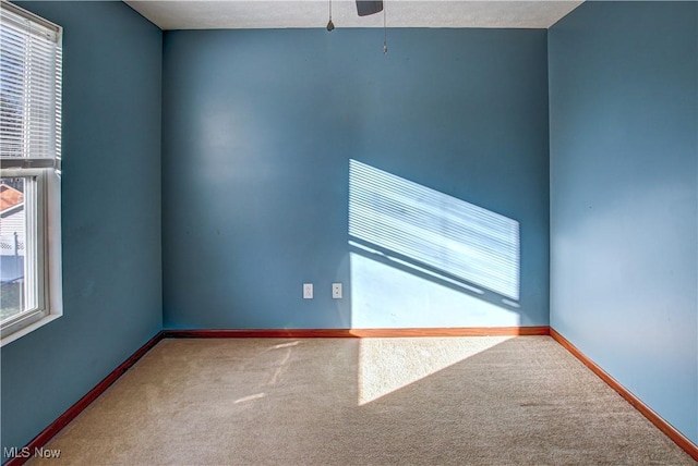 carpeted spare room featuring a textured ceiling and ceiling fan