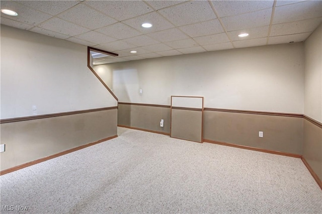 carpeted spare room with a drop ceiling