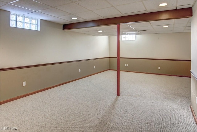 basement with carpet flooring and a paneled ceiling