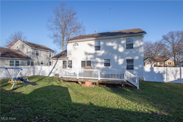 rear view of house featuring a lawn and a deck