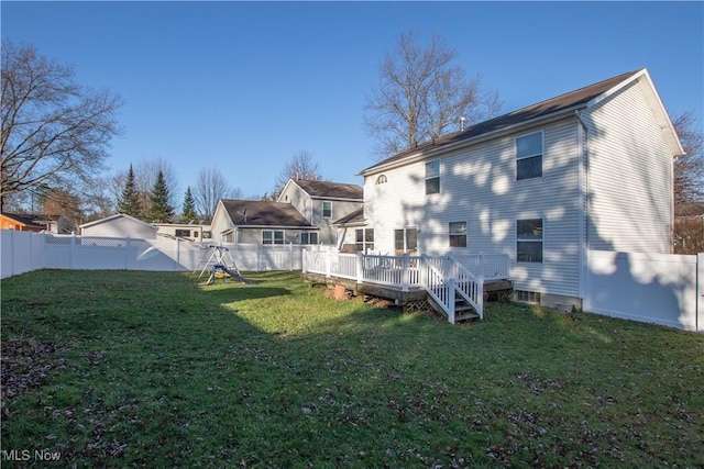 back of house featuring a lawn and a wooden deck