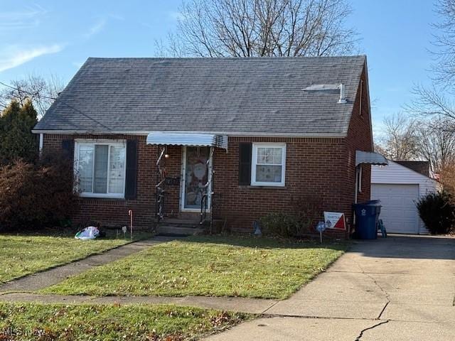 view of front facade featuring a garage, an outbuilding, and a front lawn