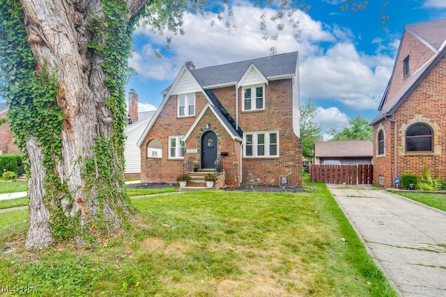 tudor home featuring a front lawn