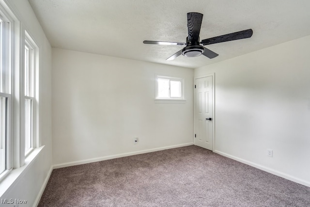 carpeted spare room featuring ceiling fan and a textured ceiling