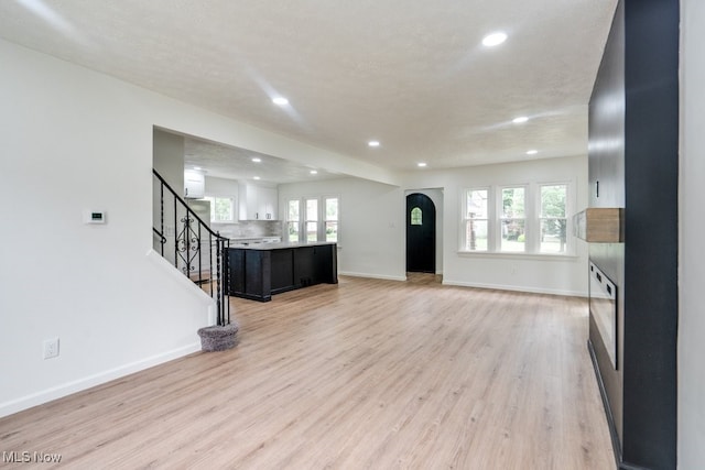 living room featuring plenty of natural light, a textured ceiling, and light hardwood / wood-style flooring