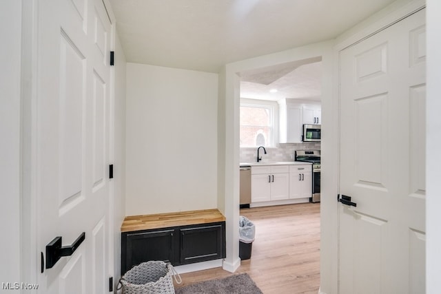 interior space with a textured ceiling, light hardwood / wood-style flooring, and sink