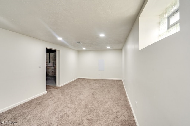 carpeted empty room with a textured ceiling