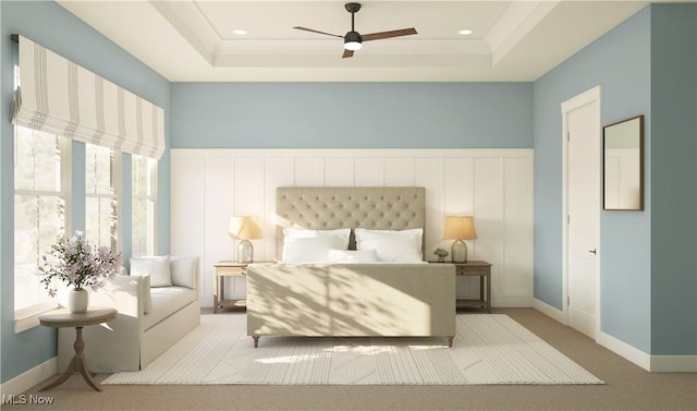 carpeted bedroom featuring ceiling fan and a raised ceiling