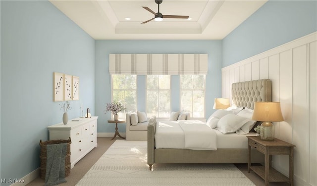 carpeted bedroom featuring a raised ceiling and ceiling fan