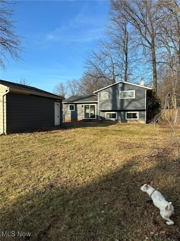 rear view of house featuring a lawn