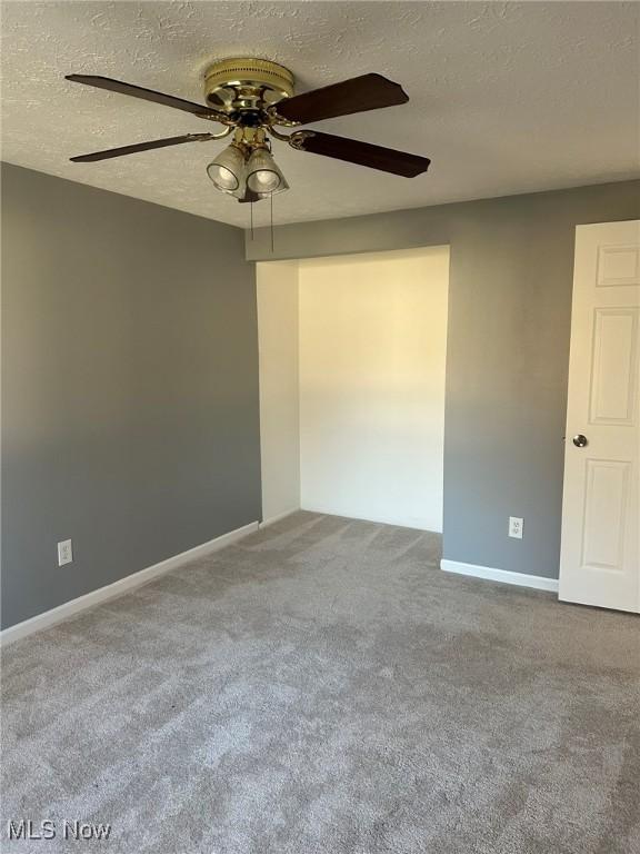 unfurnished room featuring carpet flooring, a textured ceiling, and ceiling fan