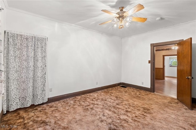 carpeted empty room with ceiling fan and crown molding