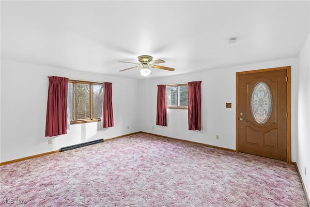 carpeted foyer entrance featuring ceiling fan and a baseboard heating unit