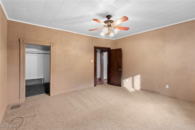 unfurnished bedroom with ceiling fan, a closet, and carpet floors