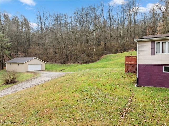 view of yard with a garage, an outdoor structure, and a wooden deck