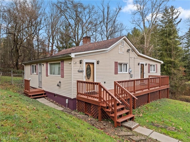 view of front of home featuring a front yard and a deck