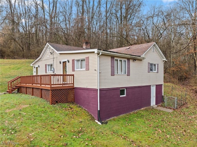 view of home's exterior with a deck and a lawn