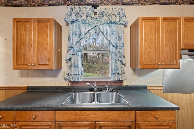 kitchen featuring wood walls and sink