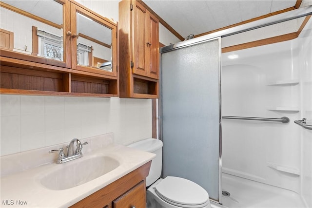 bathroom featuring backsplash, toilet, vanity, and walk in shower