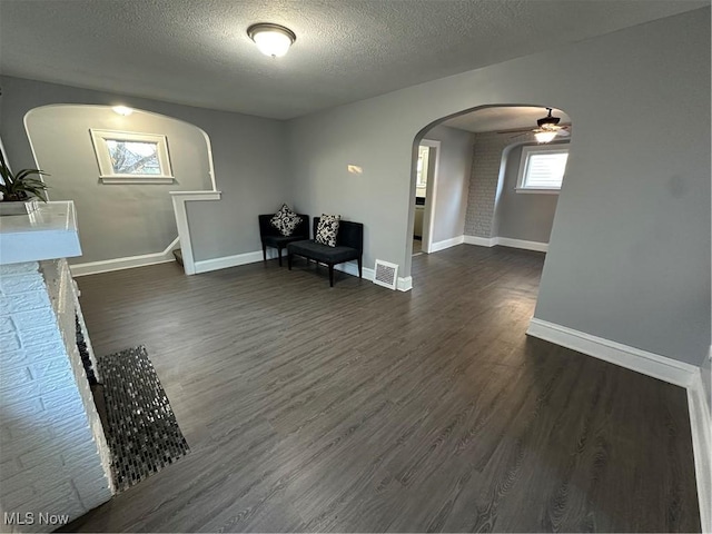 sitting room featuring ceiling fan, dark hardwood / wood-style flooring, and a textured ceiling