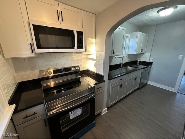 kitchen with white cabinets, sink, dark hardwood / wood-style floors, tasteful backsplash, and electric range oven