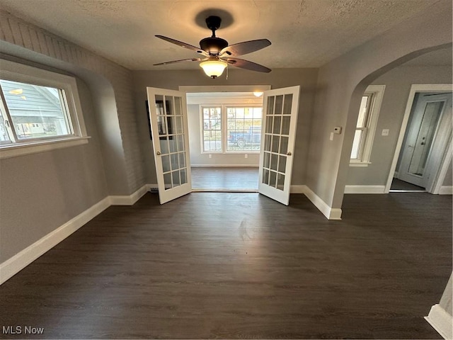 interior space with dark hardwood / wood-style floors, ceiling fan, a textured ceiling, and french doors