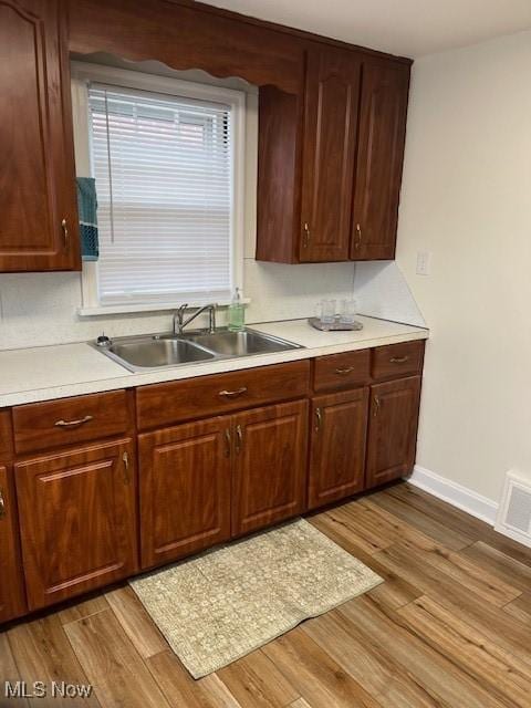 kitchen with light hardwood / wood-style flooring and sink