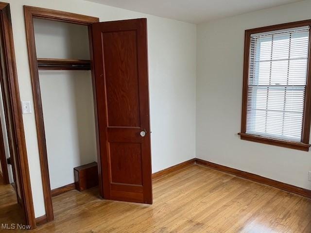 unfurnished bedroom with a closet and light hardwood / wood-style floors