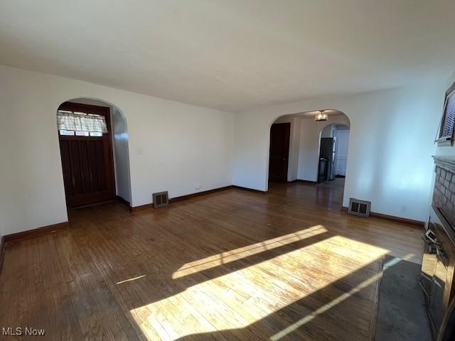 unfurnished living room with a fireplace and dark hardwood / wood-style floors