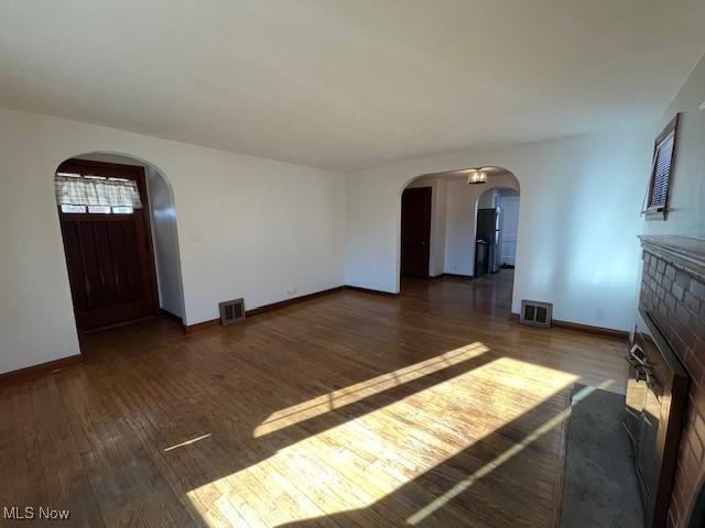 unfurnished living room with dark hardwood / wood-style floors and a fireplace