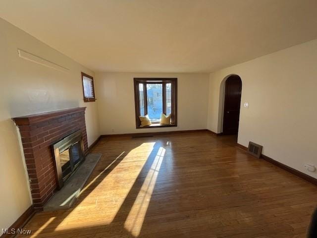 unfurnished living room with a fireplace and dark hardwood / wood-style flooring