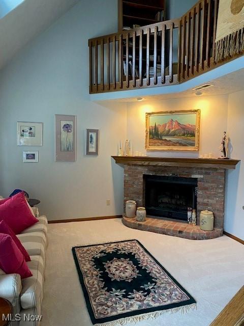 carpeted living area featuring high vaulted ceiling, a fireplace, visible vents, and baseboards