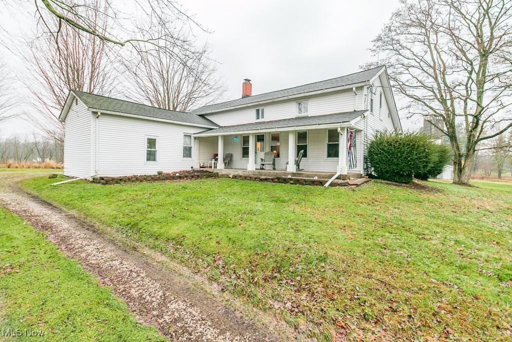 view of front of house featuring covered porch and a front yard