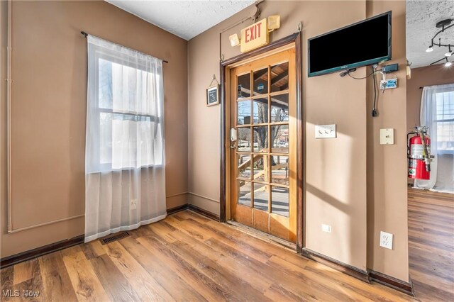 entryway with wood-type flooring and a textured ceiling