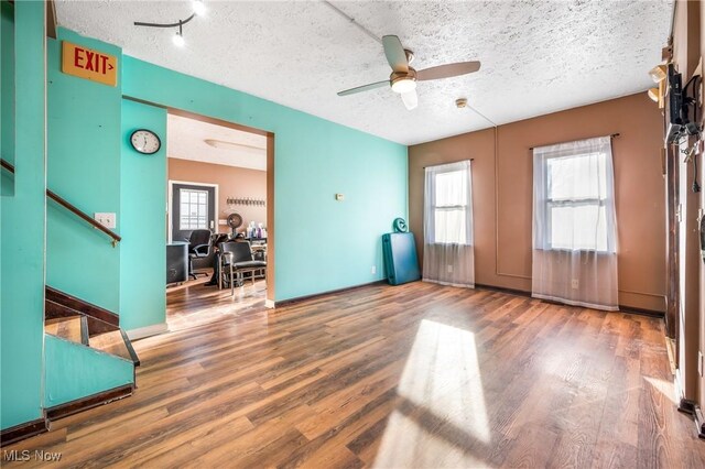 interior space with a textured ceiling, hardwood / wood-style flooring, and ceiling fan