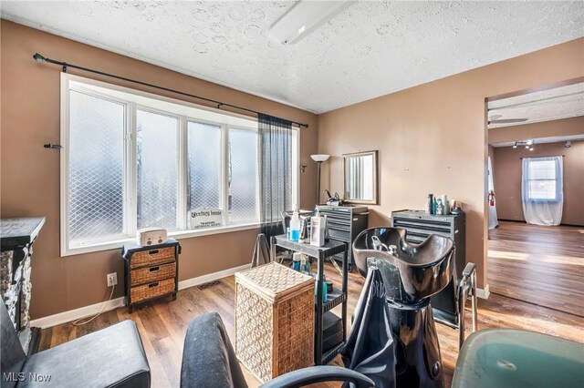 home office featuring ceiling fan, a textured ceiling, and light wood-type flooring